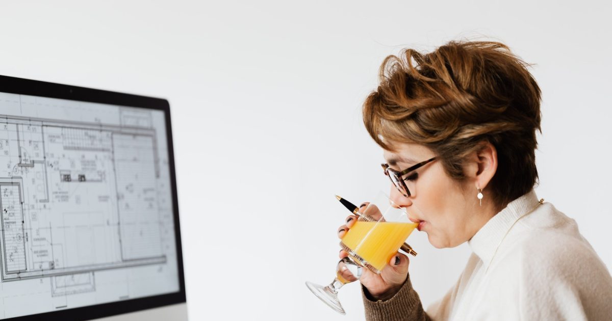 Female architect drinking juice while working on new project : Advance Payment Bond