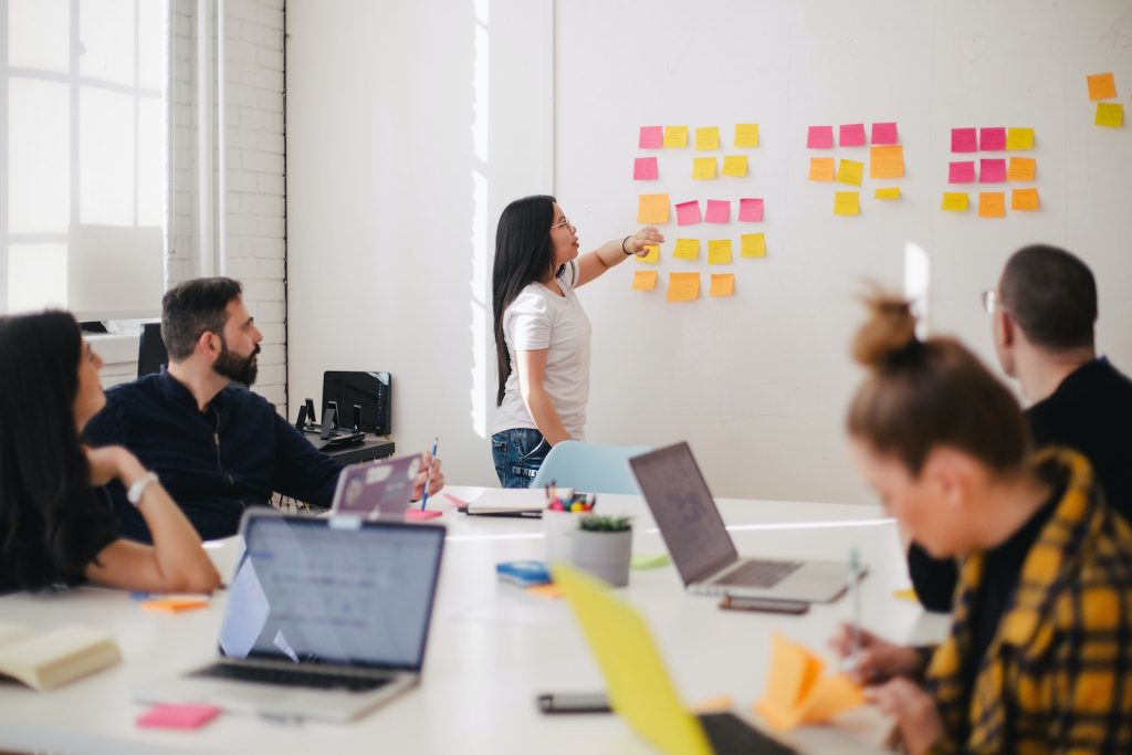 woman placing sticky notes on wall : stakeholder Managment of construction project