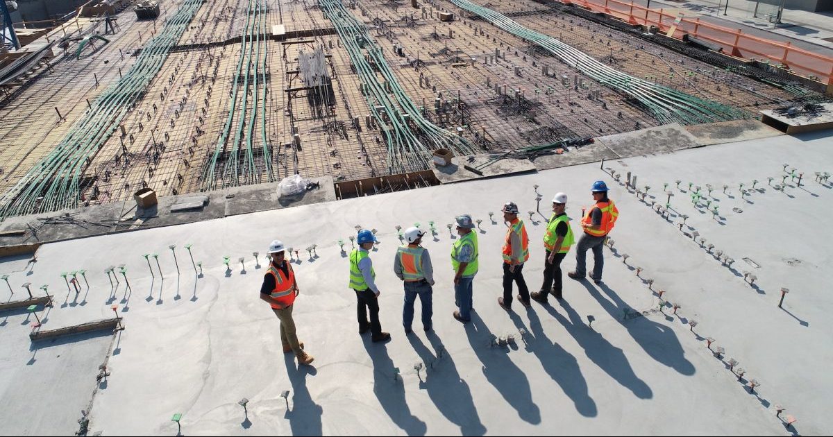 seven construction workers standing on white field : stakeholders in construction project and stakeholder management