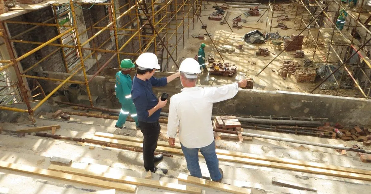man in white long sleeve shirt and blue denim jeans standing on white metal ladder : preliminaries in Construction