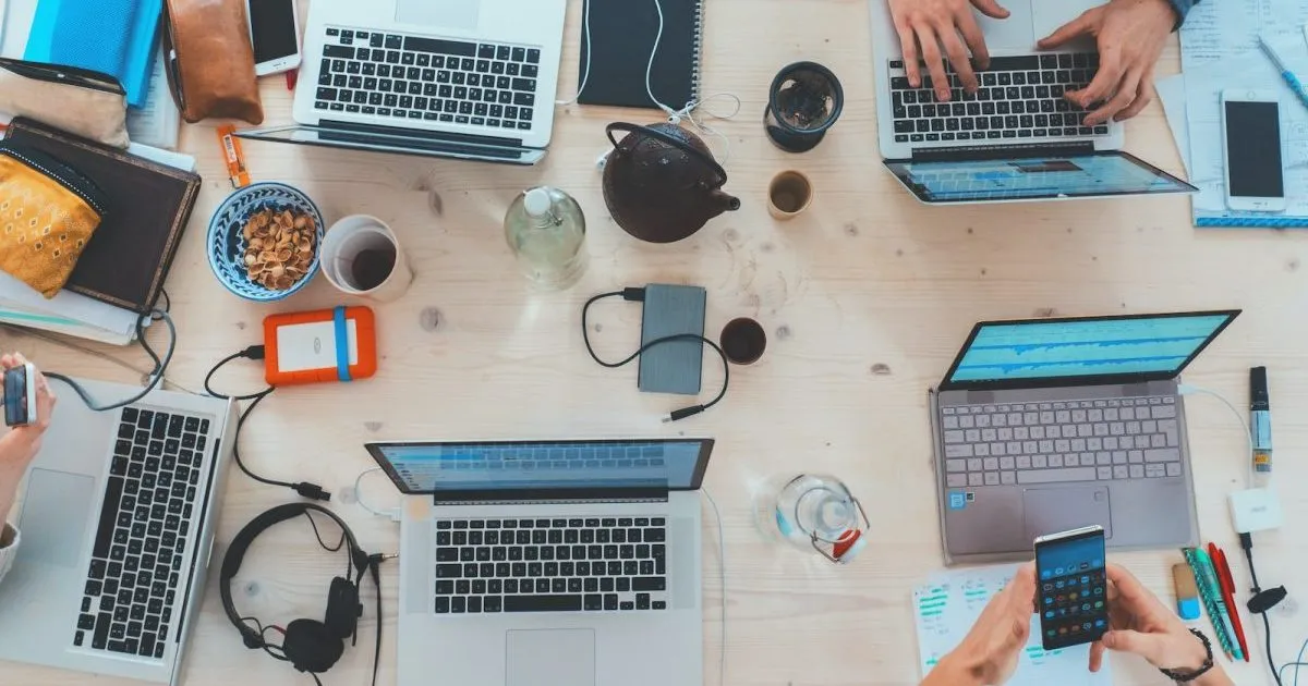 people sitting down near table with assorted laptop computers - BOQ Meaning
