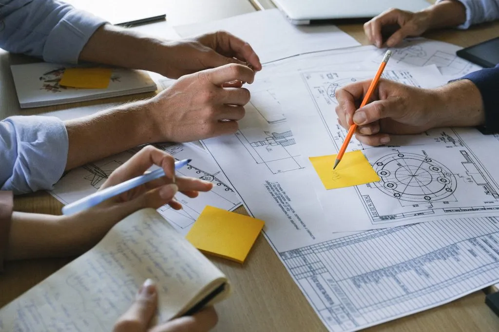 Colleagues discussing details of project on meeting, tender drawings,