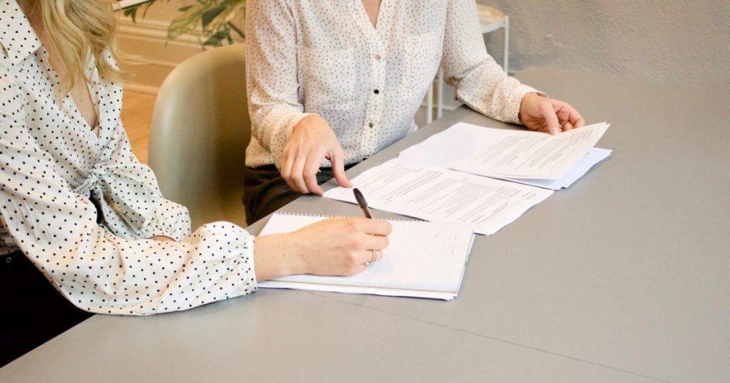 woman signing on a Construction Bonds