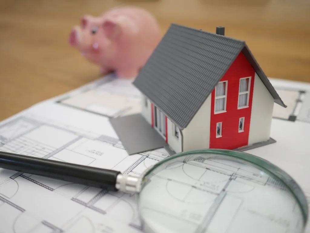 white and red wooden house beside grey framed magnifying glass, Cost of Construction Bond