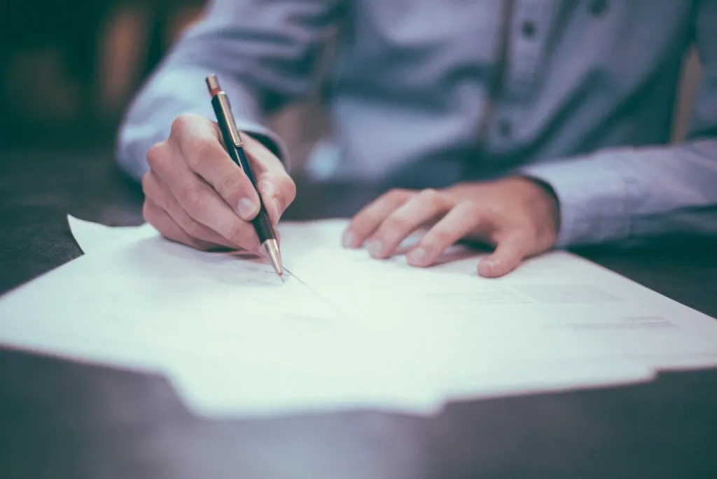 man writing on paper, Signing the contract agreement