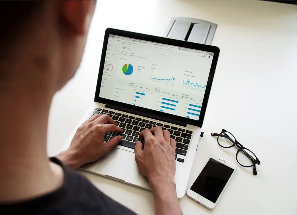 person using MacBook Pro, Reviewing pricing and cost breakdowns in construction tenders